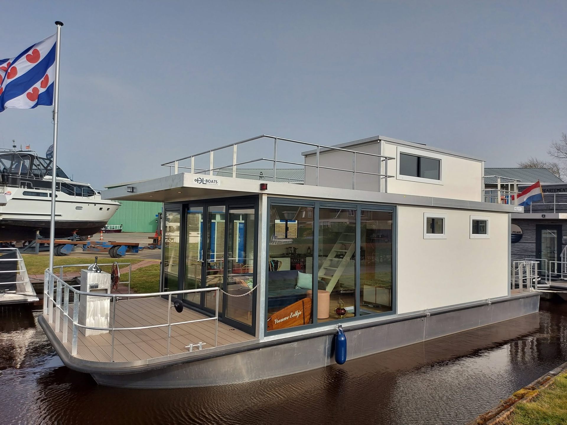 Aluminium houseboat op stil water bij zonsopgang